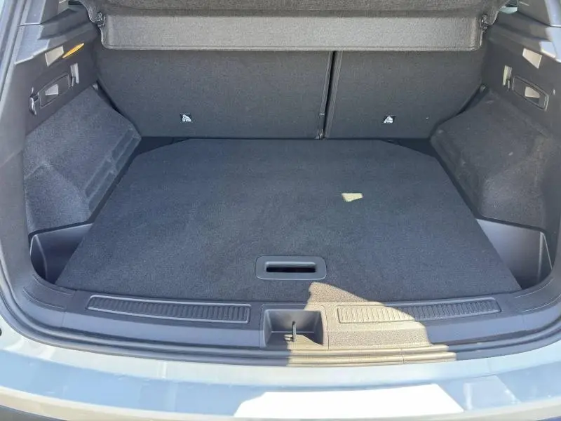 Coffre ouvert du Renault Austral blanc nacré, vue de l'arrière montrant un espace de chargement propre et bien agencé.