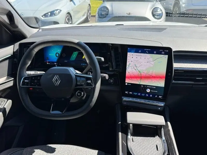 Vue intérieure frontale du tableau de bord et volant noir du Renault Austral 2025 avec écran tactile vertical et affichage numérique.