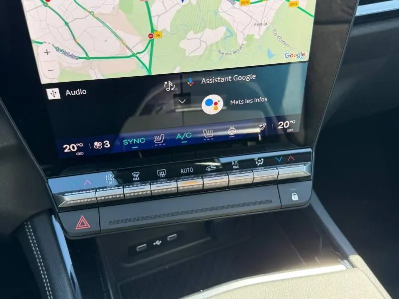 Vue rapprochée de la console centrale tactile du Renault Austral blanc nacré avec toit noir, affichant la climatisation et la navigation.