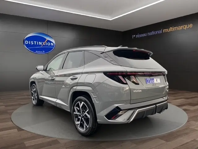 Vue 3/4 arrière droite du Hyundai Tucson 1.6 Hybrid gris foncé avec hayon motorisé et jantes alliage distinctives.