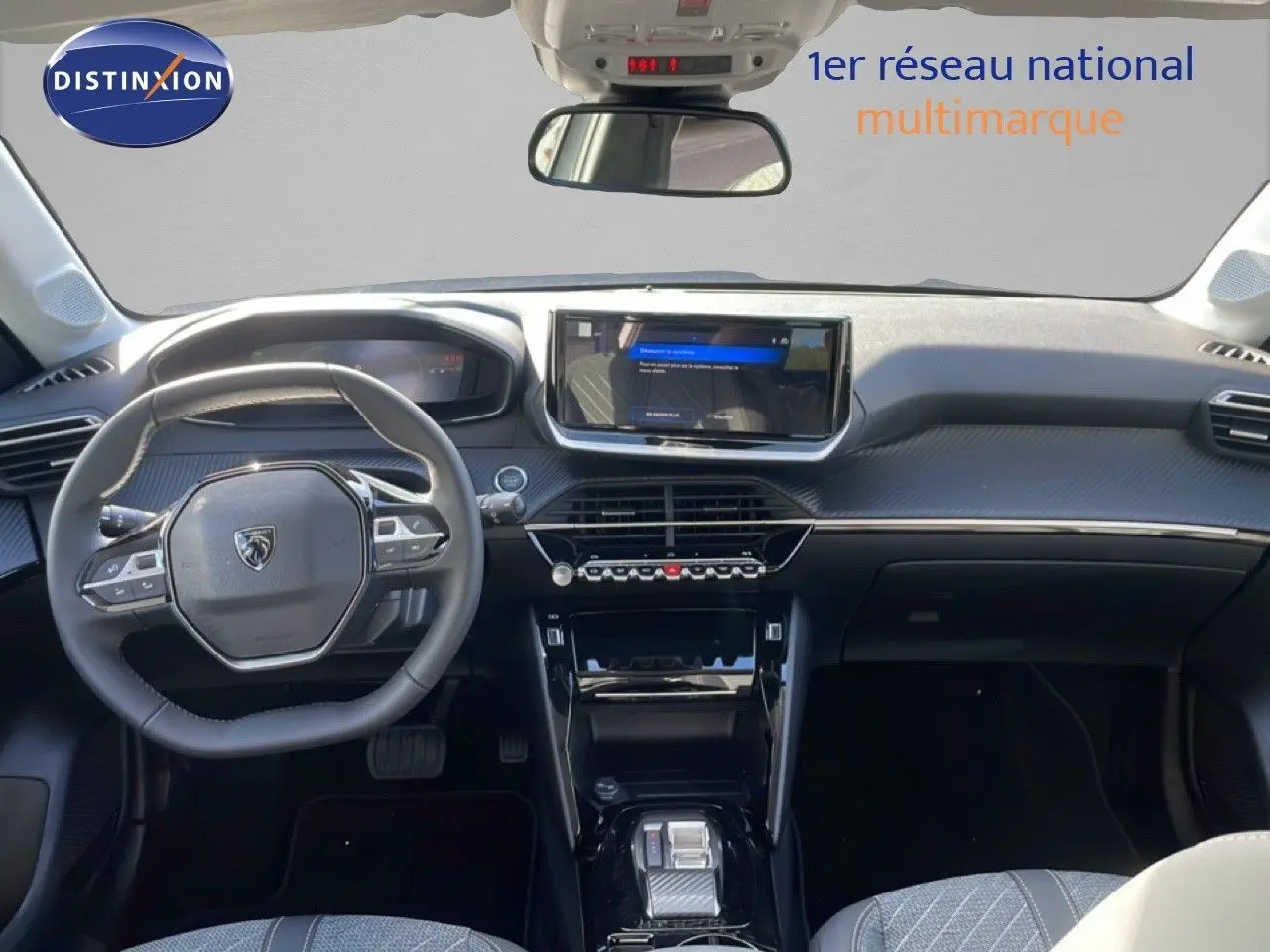Intérieur de la Peugeot 208 Hybrid blanc Okenite, vue frontale du tableau de bord avec écran tactile et volant multifonction.