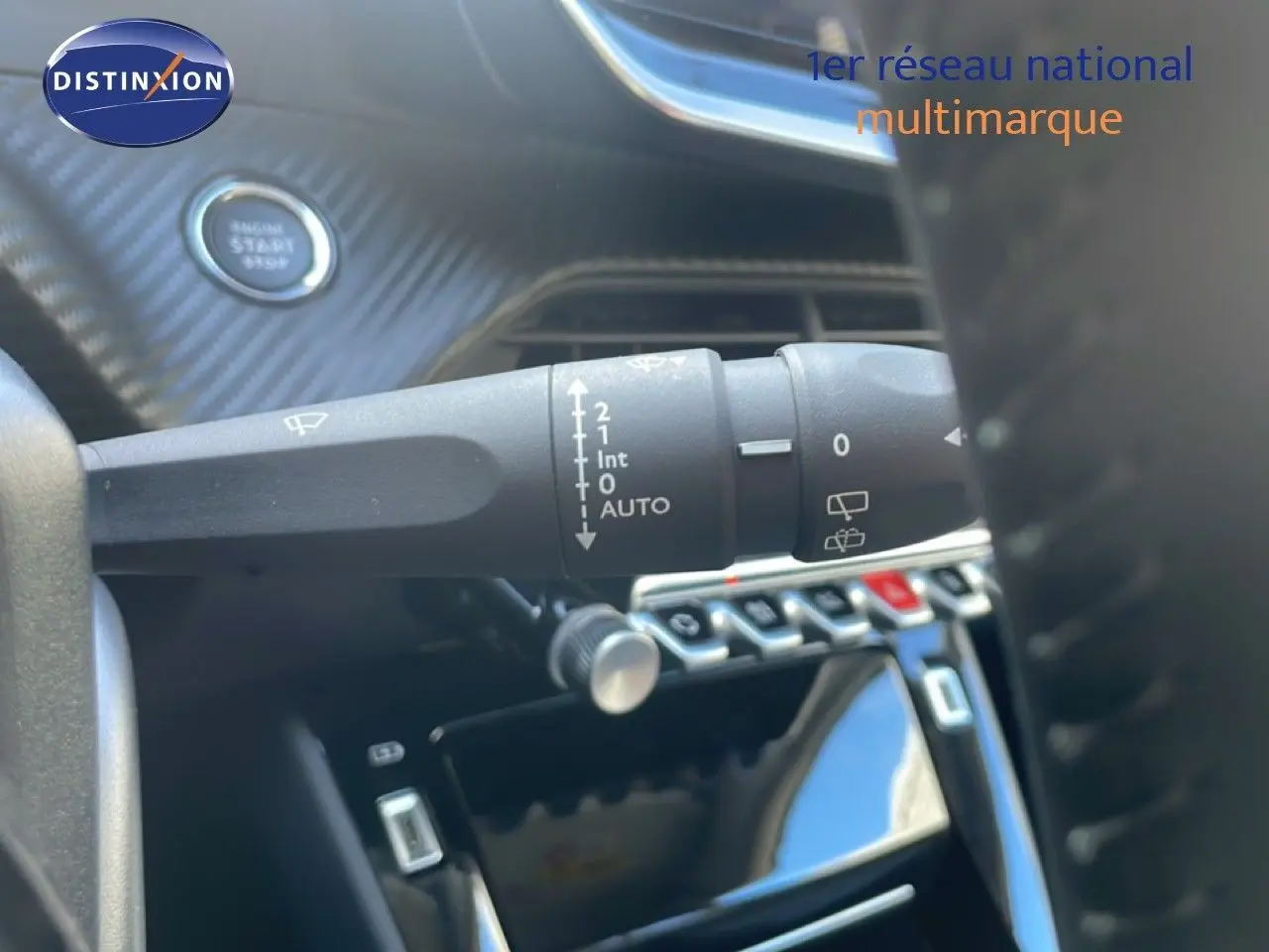Gros plan sur la commande d’essuie-glace et le bouton start du tableau de bord intérieur d’une Peugeot 208 blanche.