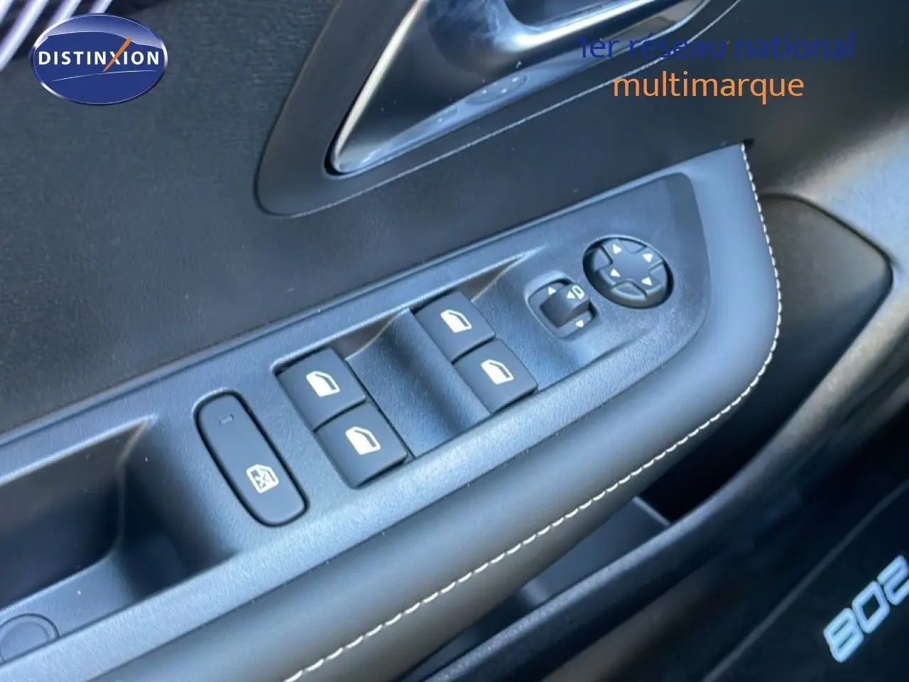 Gros plan sur les commandes de lève-vitres et rétroviseurs côté conducteur d’une Peugeot 208 blanche hybride 2026.