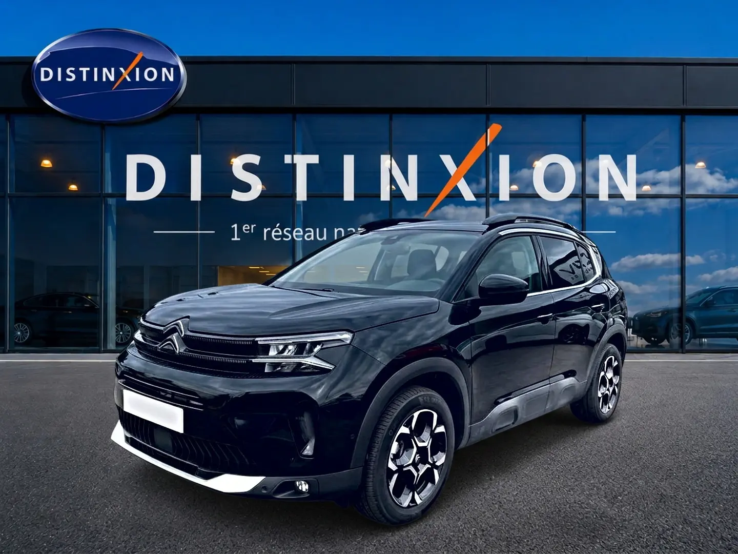 Citroën C5 Aircross noir vue 3/4 avant droit avec jantes alu et barres de toit devant showroom Distinxion.