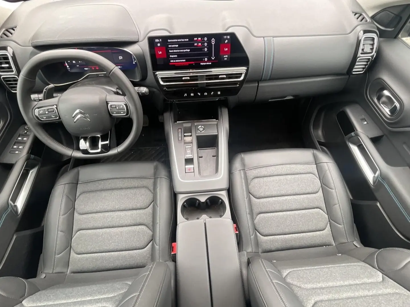 Vue intérieure de face du poste de conduite du Citroën C5 Aircross 2025 avec sièges cuir et écran tactile central.