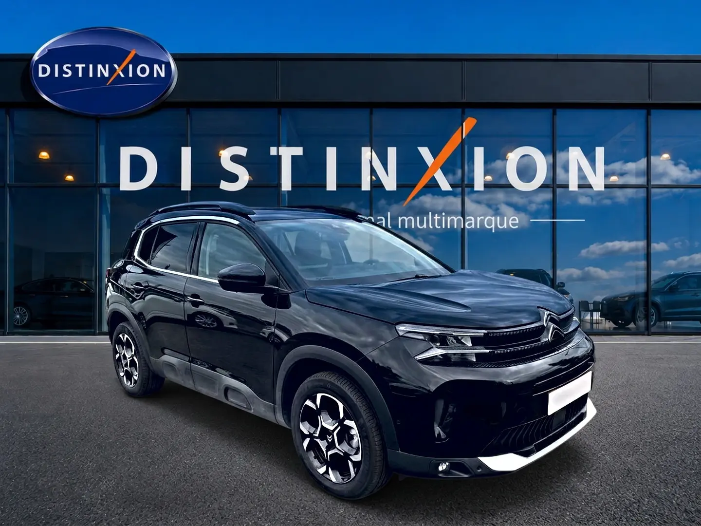 Citroën C5 Aircross noir en 3/4 avant droit, avec jantes alu distinctives et barres de toit visibles.