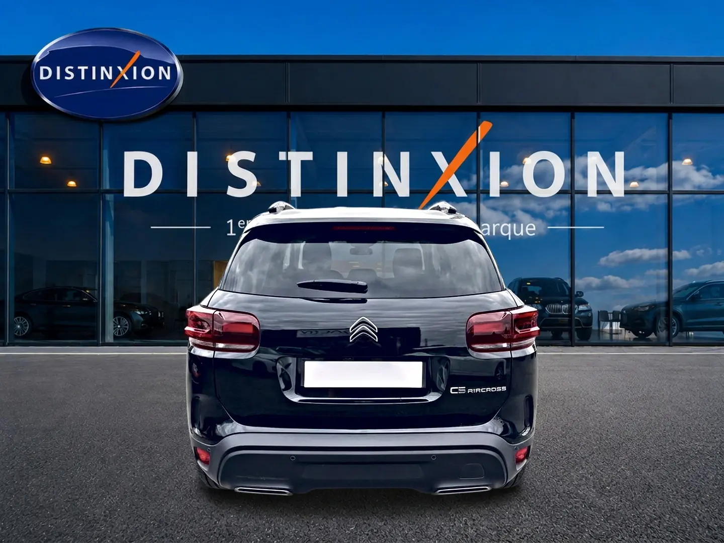 Vue arrière d'un Citroën C5 Aircross noir 2025, avec feux LED et barres de toit visibles devant une vitrine Distinxion.