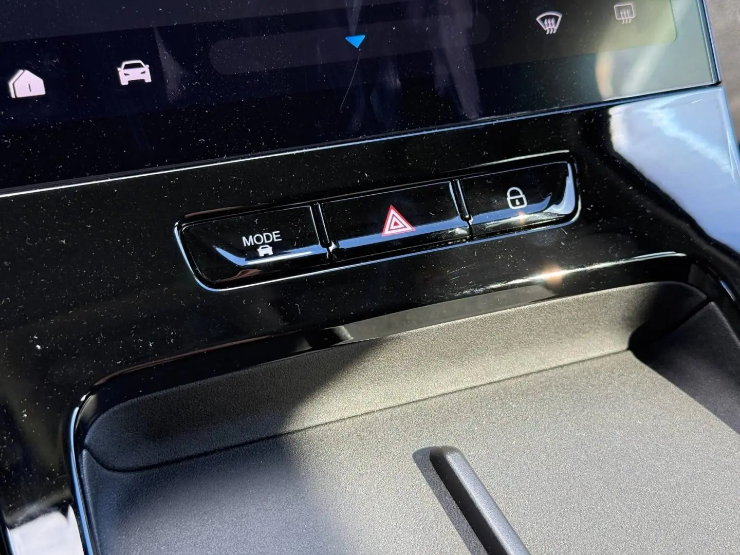 Gros plan sur la console centrale noire brillante du JAECOO J5 avec boutons mode, warning et verrouillage.