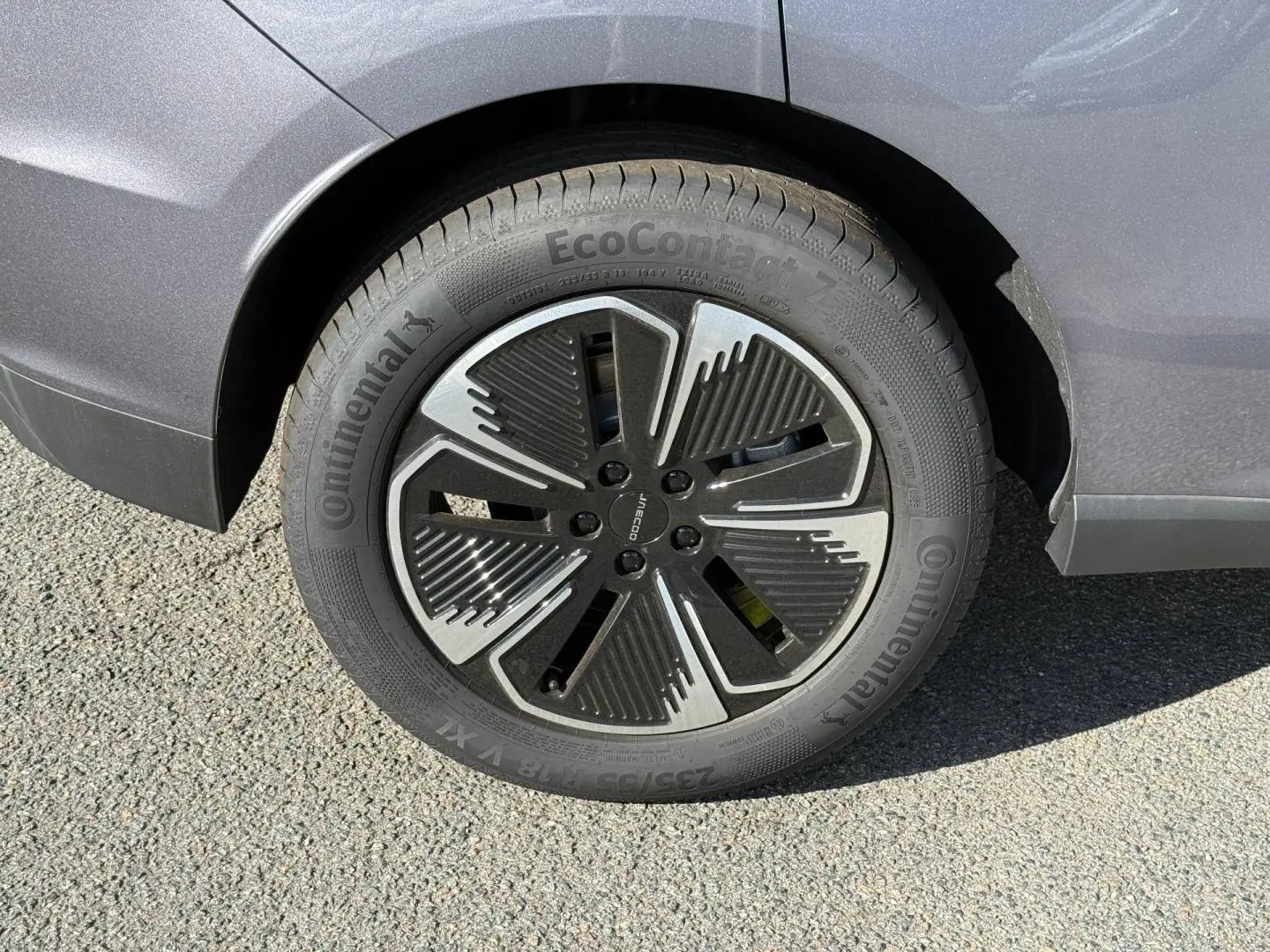 Gros plan sur la roue arrière droite du JAECOO J5 Phantom Grey métal avec jante alu au design moderne noir et argent.