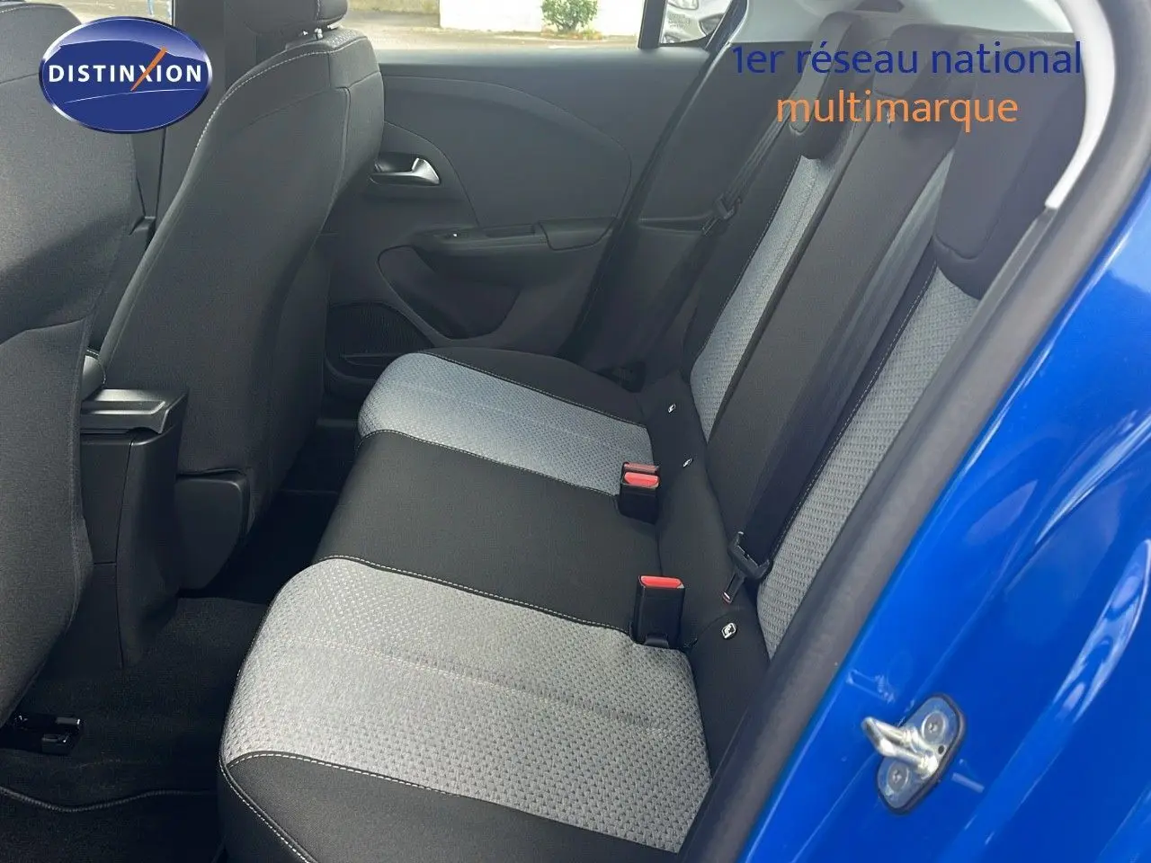 Vue intérieure arrière côté droit de l'Opel Corsa 2025 bleu voltaik métal, sièges tissu gris et noir avec ceinture de sécurité.