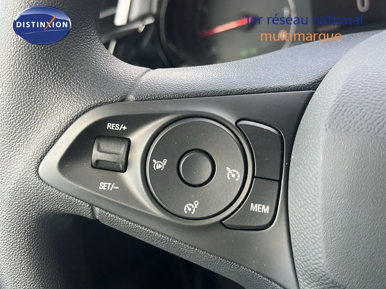 Gros plan sur les commandes de régulateur de vitesse au volant d'une Opel Corsa bleu Voltaik Metal 2025.