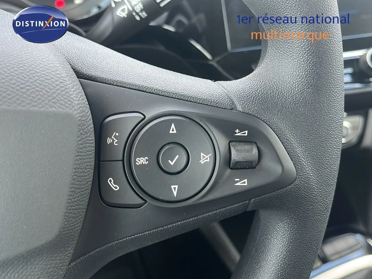 Gros plan sur les commandes multifonctions au volant d'une Opel Corsa 2025, finition Bleu Voltaik Metal.