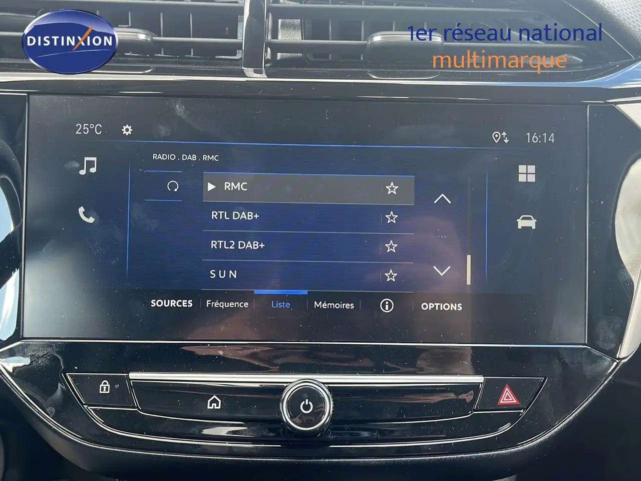 Écran tactile central de la console d'une Opel Corsa bleu Voltaik Metal, affichant les stations radio numériques.