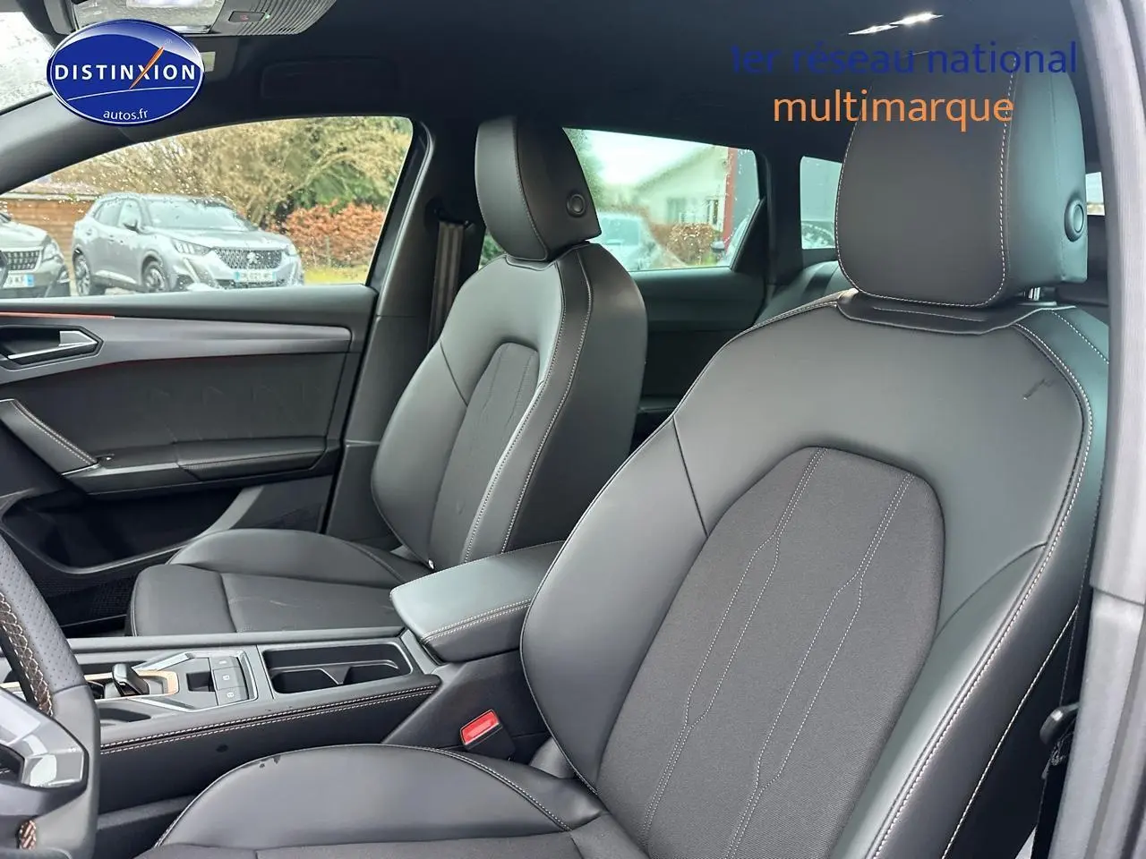 Vue intérieure côté avant droit de la CUPRA LEON ST 1.5 etsi hybrid 2025 avec sièges cuir noirs et surpiqûres contrastées.