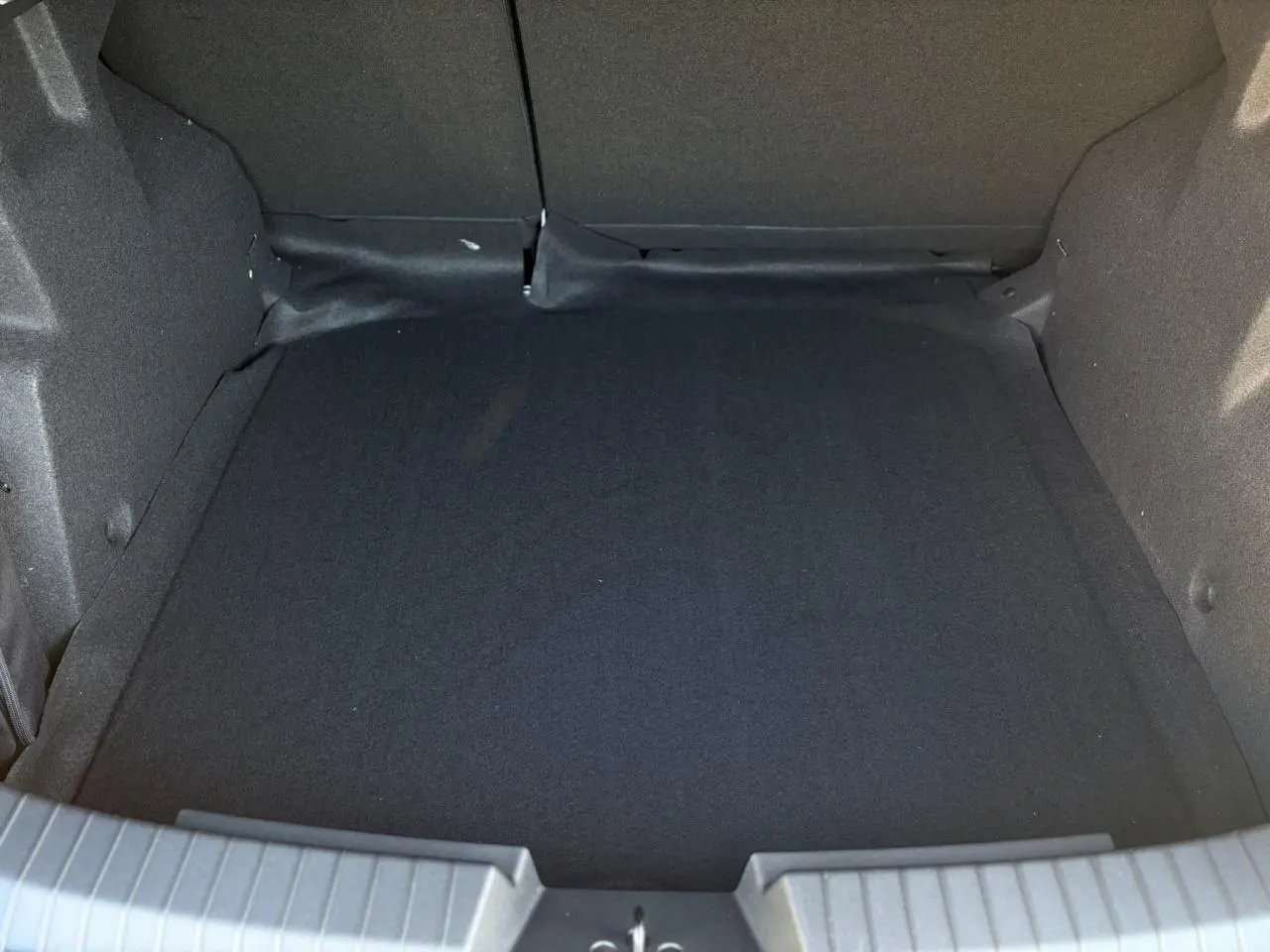 Coffre vide vu de dessus du Dacia Duster noir nacré, montrant l'espace de chargement intérieur.