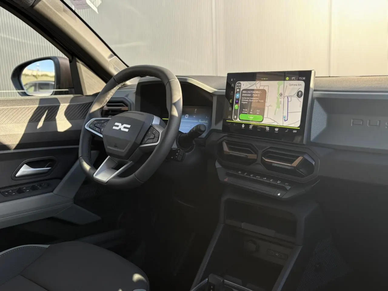 Vue intérieure côté conducteur du Dacia Duster 2026, avec tableau de bord digital et écran tactile GPS lumineux.