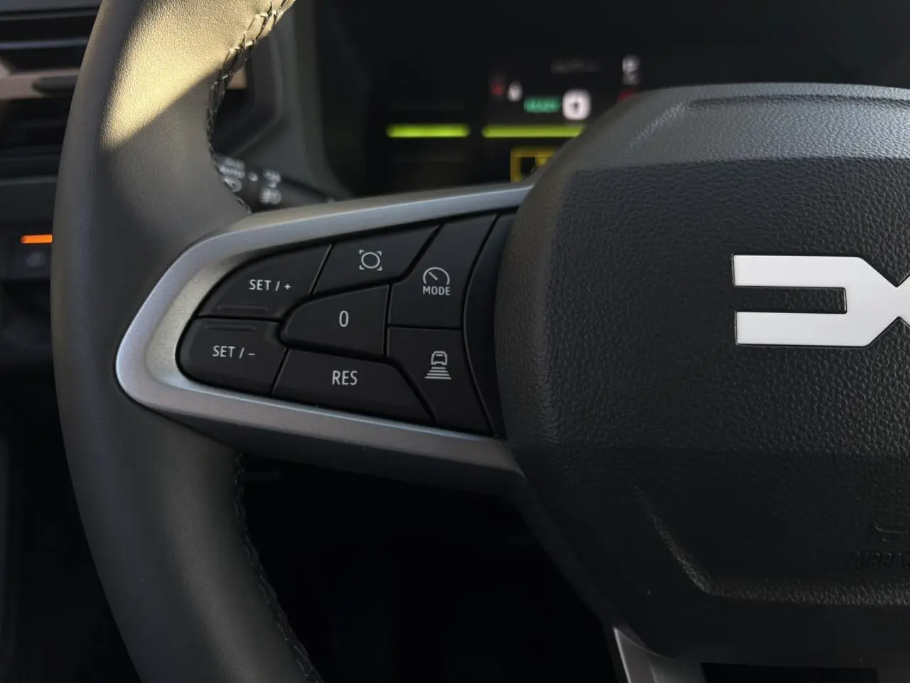 Gros plan sur le côté gauche du volant noir du Dacia Duster 2026 avec commandes de régulateur de vitesse.
