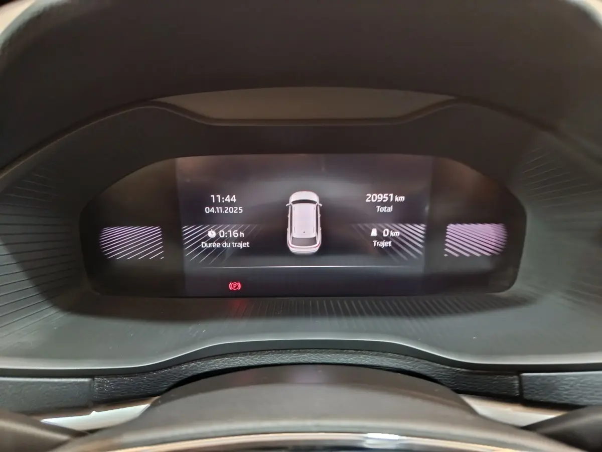 Affichage numérique du combiné d'instruments du Skoda Karoq blanc, montrant la distance totale et durée du trajet.