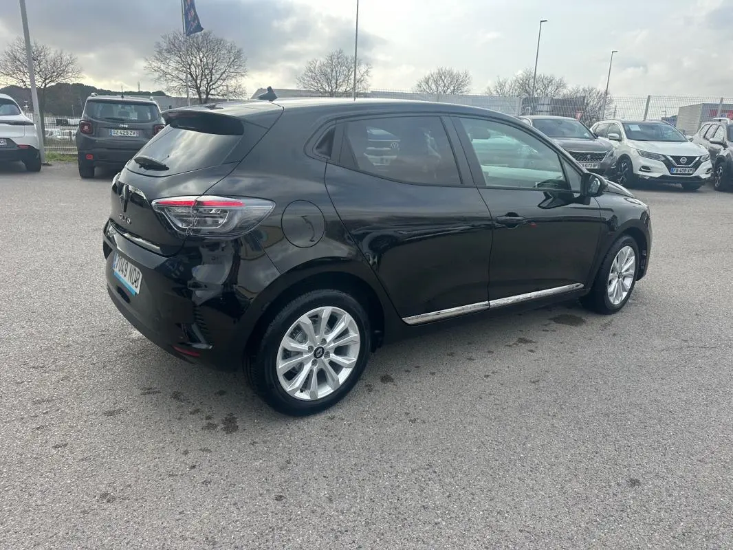 Vue 3/4 arrière droite d'une Renault Clio noire 2025 avec vitres surteintées et jantes argentées.