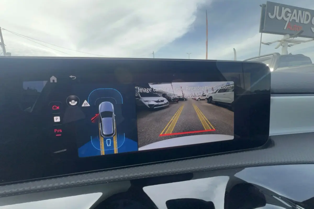 Écran de caméra de recul d'une Mercedes Classe A 200D blanche, affichant la vue arrière avec lignes de guidage jaunes.