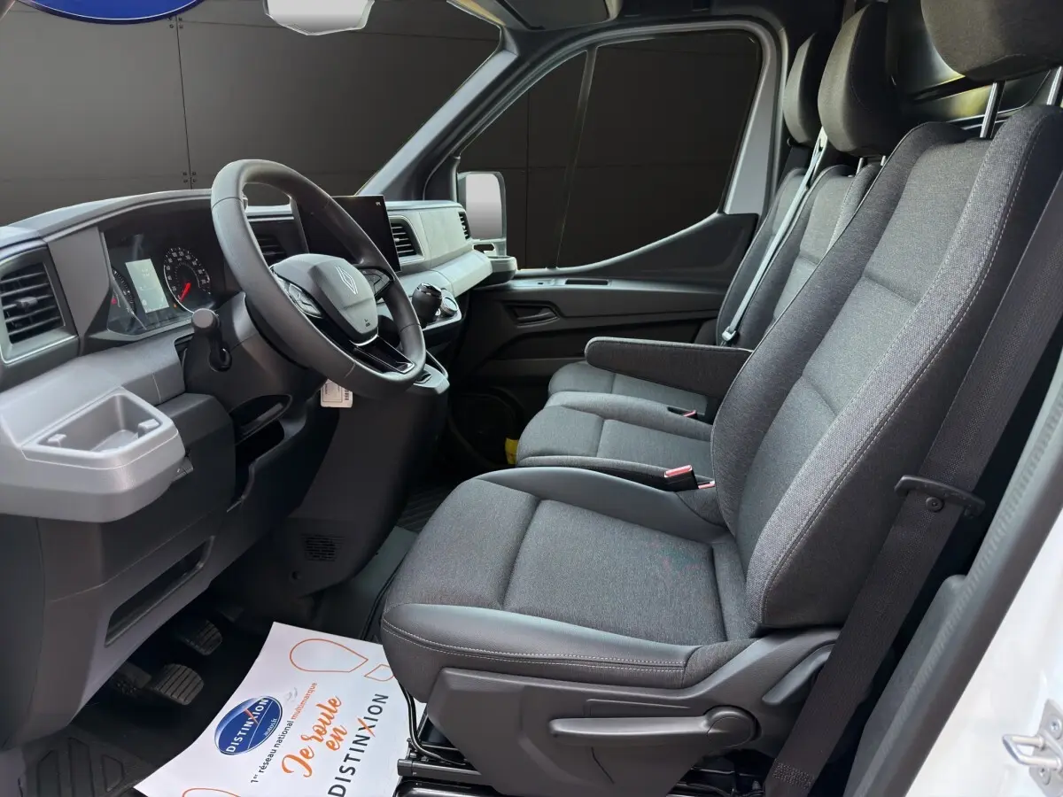 Vue intérieure côté conducteur du Renault Master 2026 avec sièges gris, volant réglable et tableau de bord moderne.