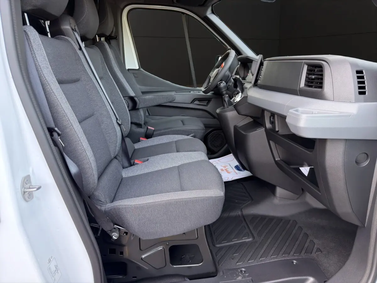 Vue intérieure côté conducteur du Renault Master blanc 2026, montrant les sièges gris et le tableau de bord moderne.
