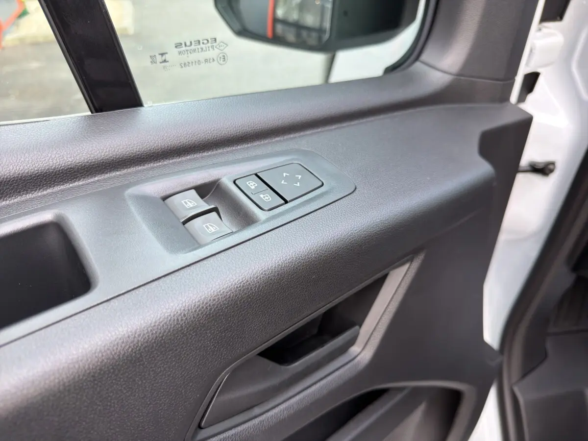Gros plan sur la porte avant gauche du Renault Master blanc 2026, avec commandes électriques des vitres et réglage des rétroviseurs.
