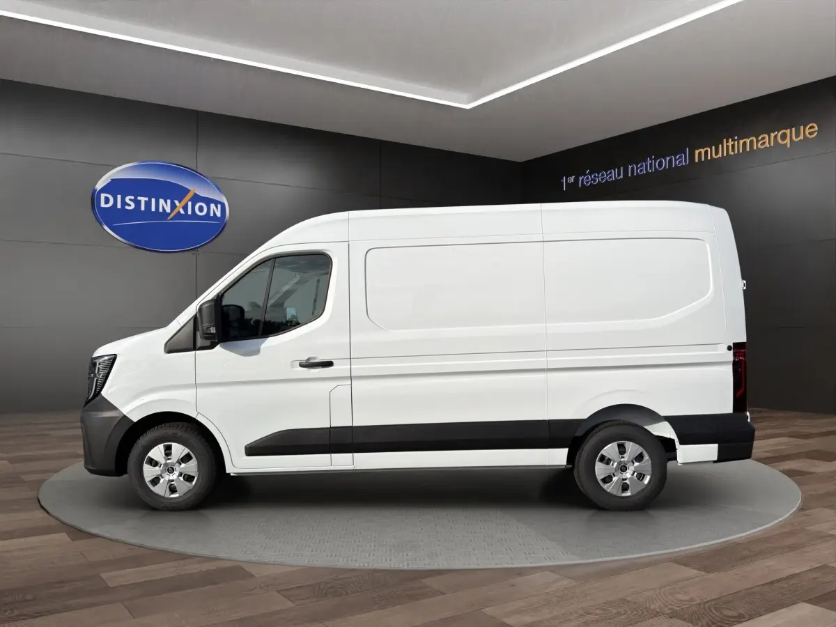 Profil droit d’un utilitaire Renault Master blanc 2026 avec bas de caisse noir et jantes acier en showroom.