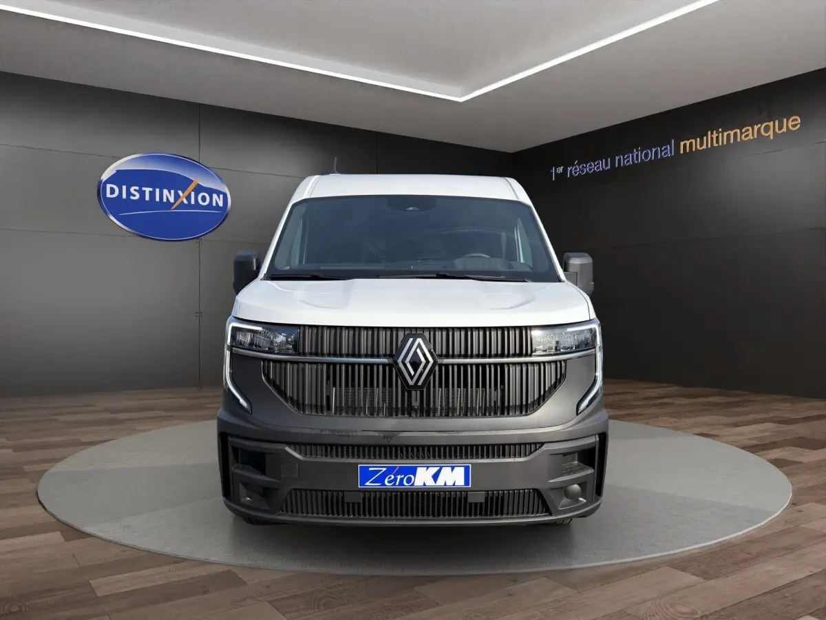 Vue avant d'un utilitaire Renault Master blanc avec calandre noire et logo Renault centré, en showroom.