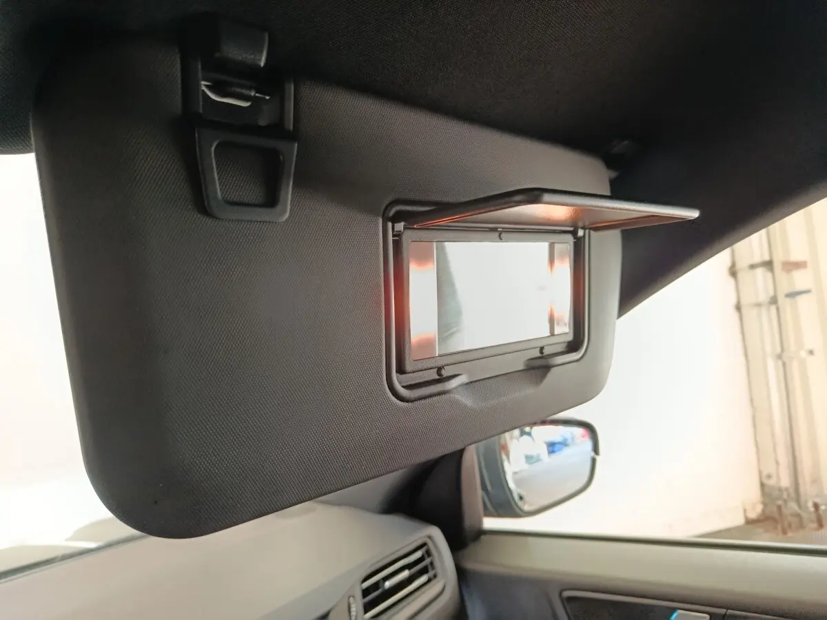 Détail du pare-soleil côté conducteur avec miroir éclairé, intérieur gris foncé du Ford Kuga 2023.