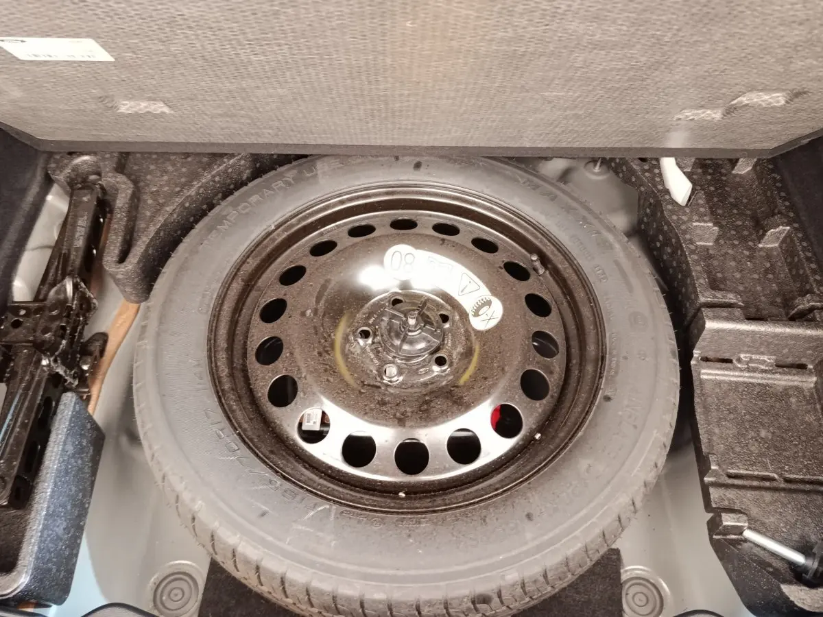 Vue rapprochée de la roue de secours noire dans le coffre du Ford Kuga gris foncé 2023.
