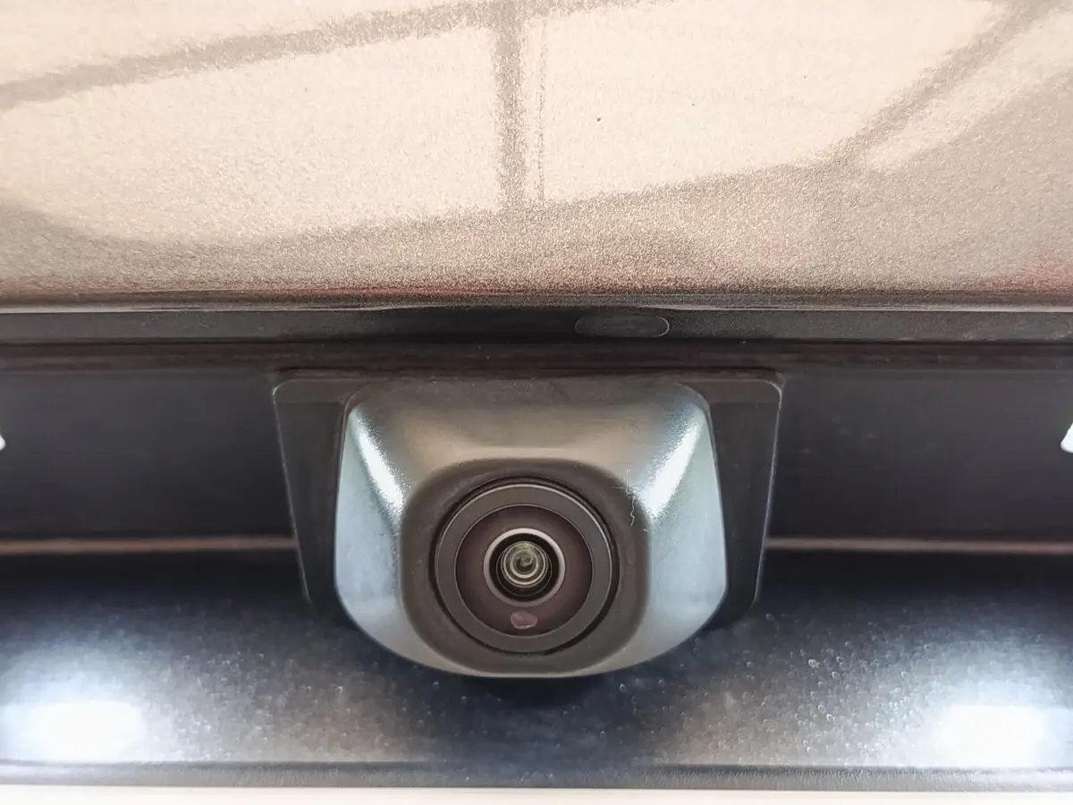 Gros plan sur la caméra de recul intégrée au hayon gris foncé du Ford Kuga 2023, version hybride ST-Line X.