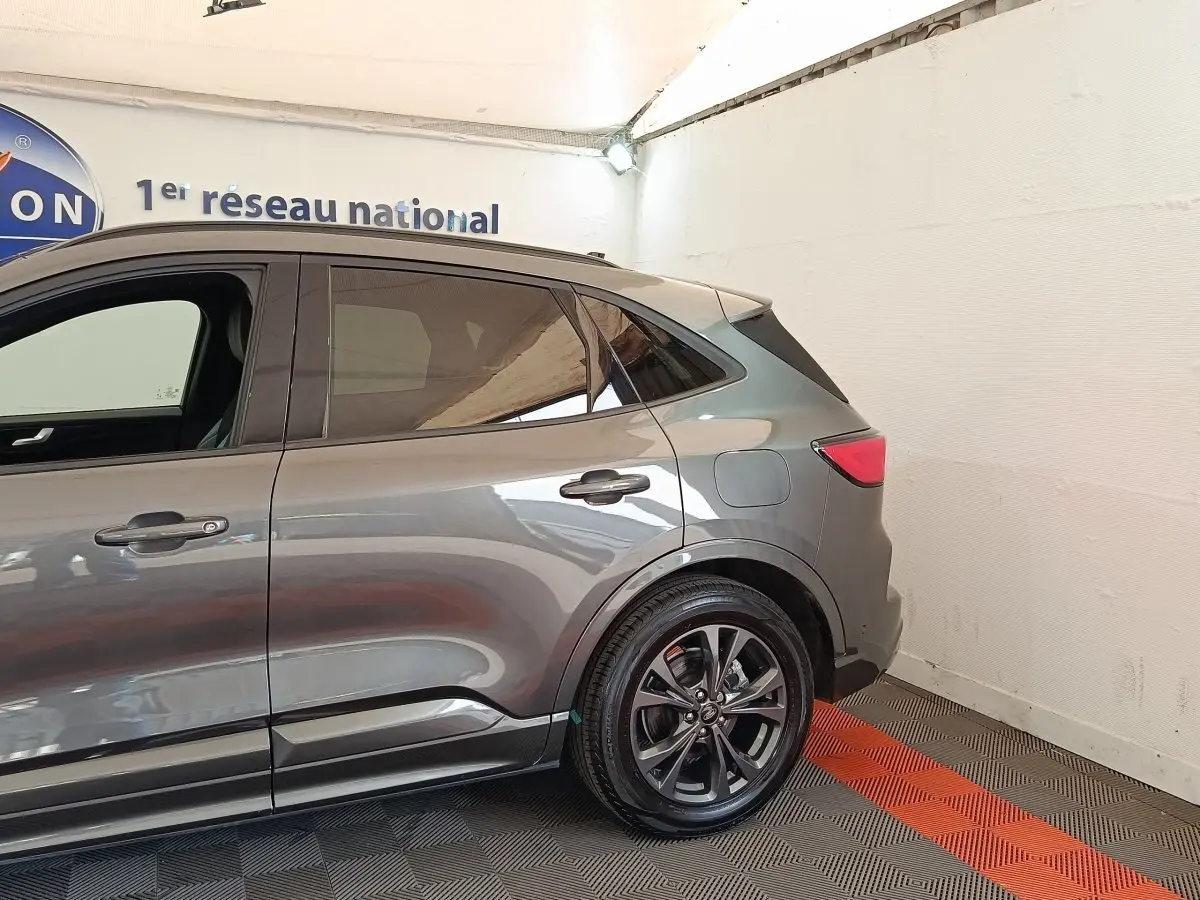 Vue côté droit arrière du Ford Kuga gris foncé 2023, avec jantes alliage et feux arrière LED visibles.