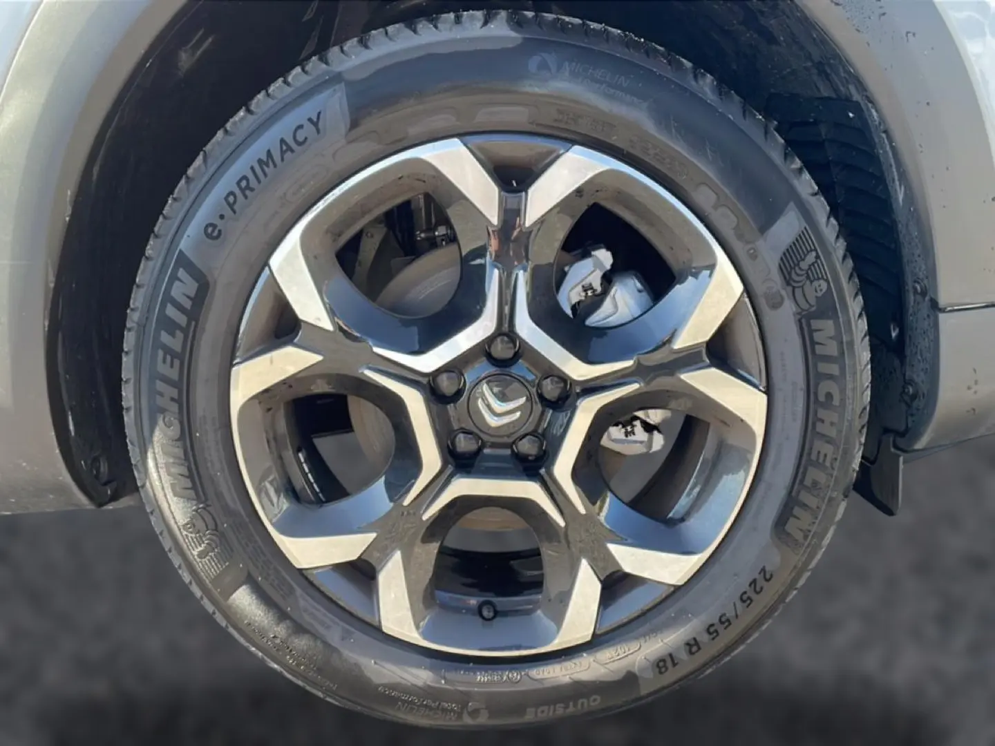 Gros plan sur la jante alu bicolore et le pneu Michelin d'un Citroën C5 Aircross blanc, côté avant droit.