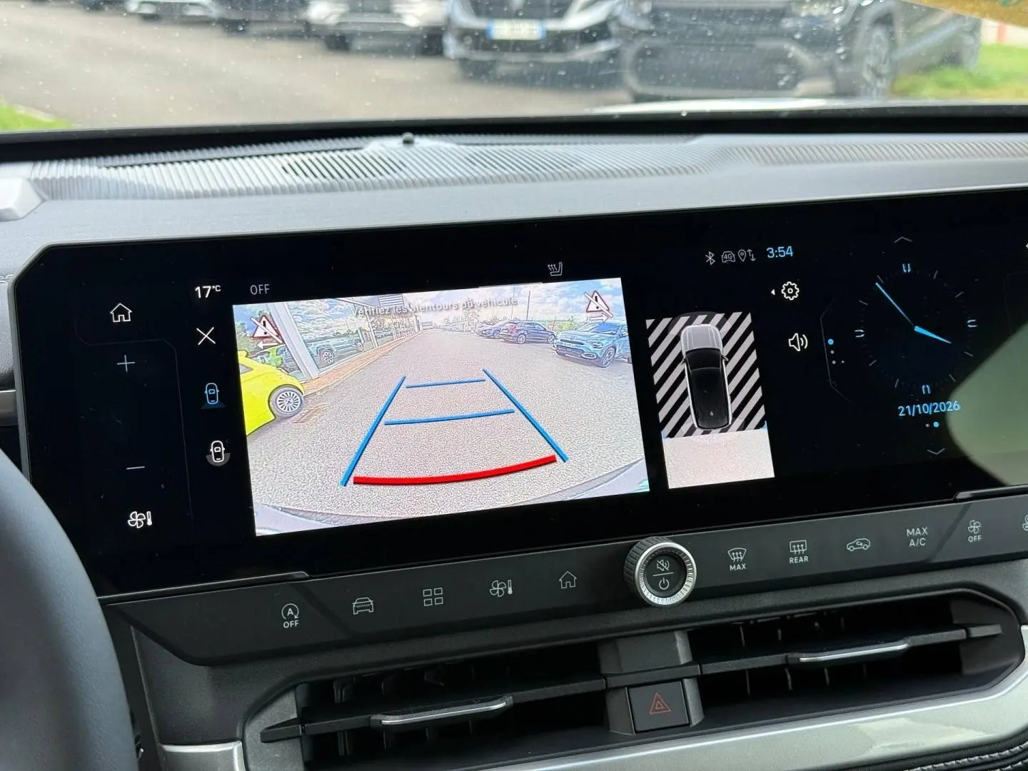 Vue intérieure du tableau de bord du Jeep Compass 2026 avec écran tactile affichant la caméra de recul et les commandes climatiques.
