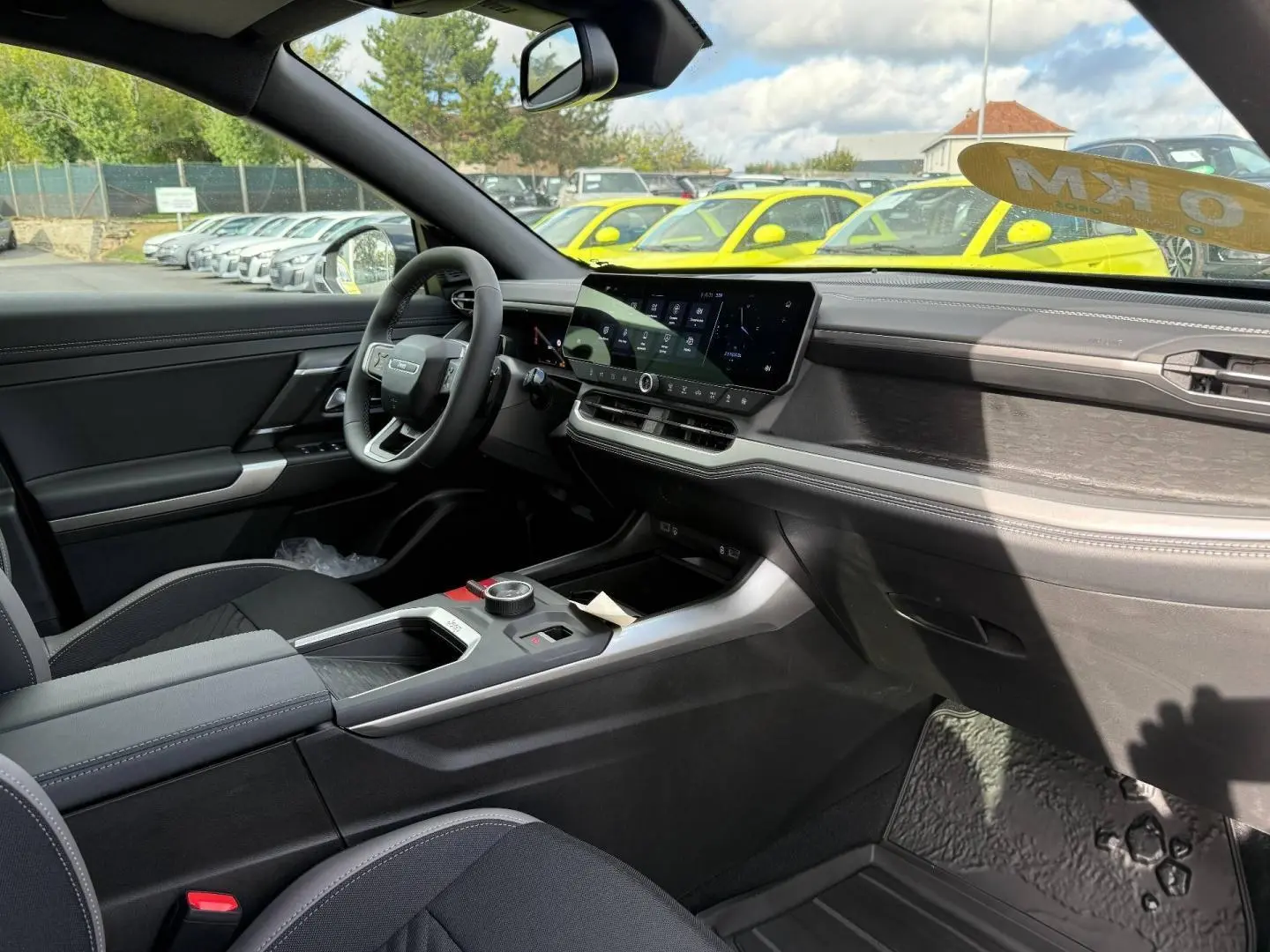Vue intérieure côté conducteur du Jeep Compass 2026, tableau de bord moderne avec écran tactile et finitions noires et grises.