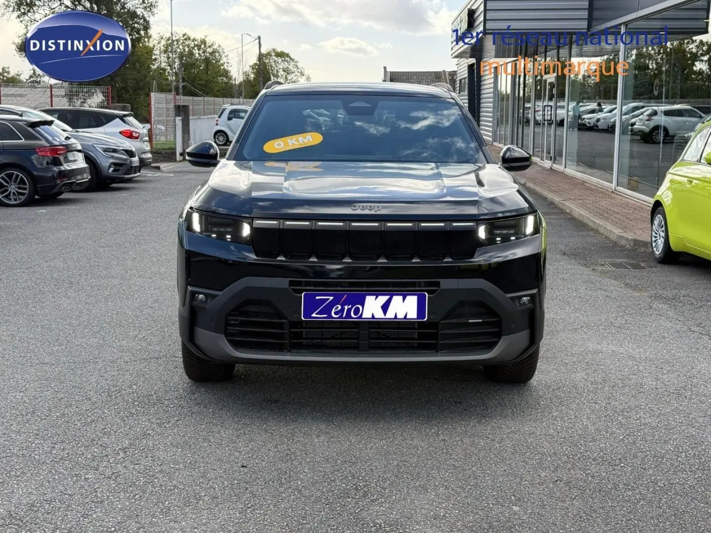 Vue avant d'un Jeep Compass 2026 couleur Vulcano, avec calandre noire et phares LED allumés.