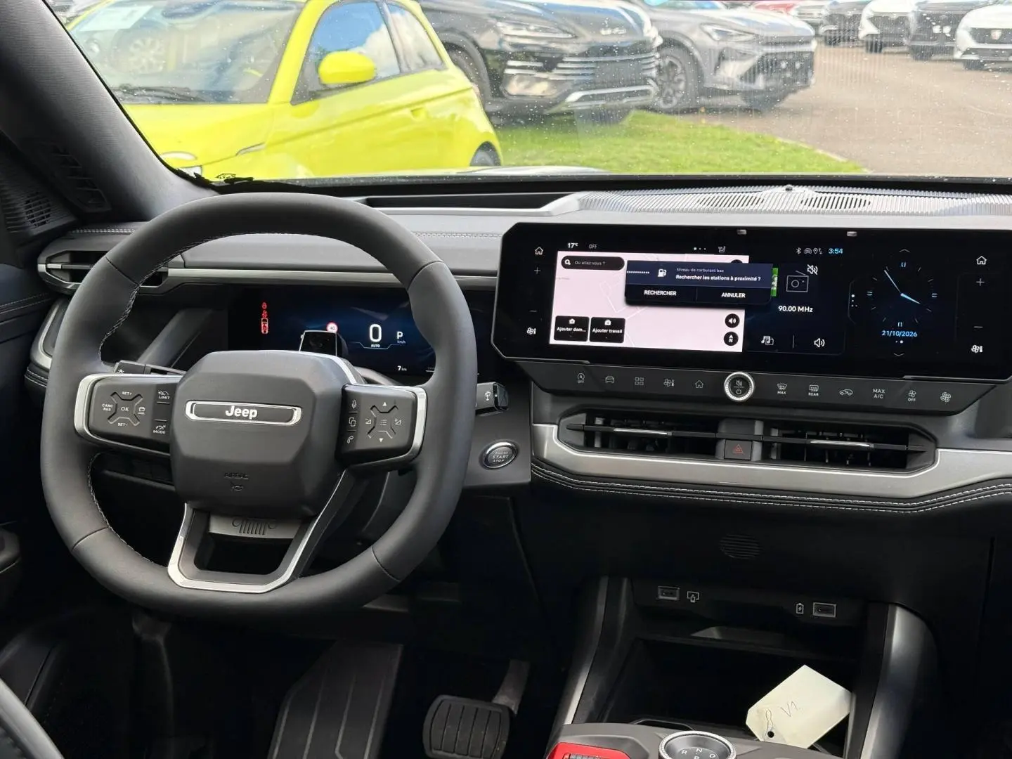 Vue intérieure avant du Jeep Compass 2026, tableau de bord noir avec écran tactile panoramique et volant multifonctions.