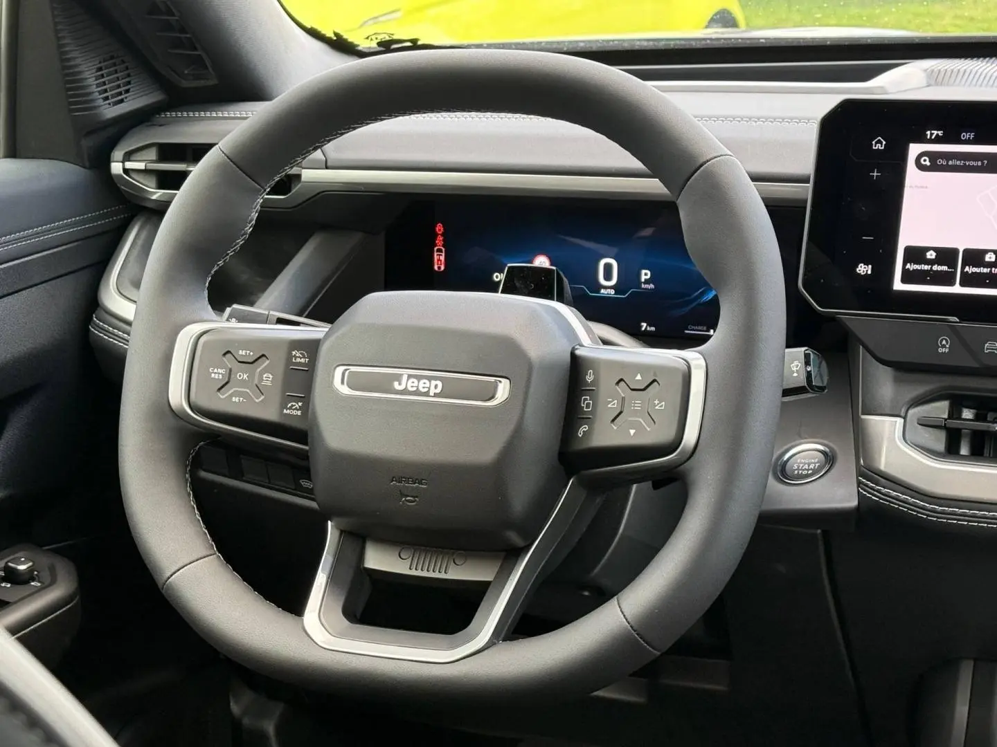 Vue rapprochée du volant Jeep Compass 2026 en cuir noir avec commandes intégrées et tableau de bord numérique.