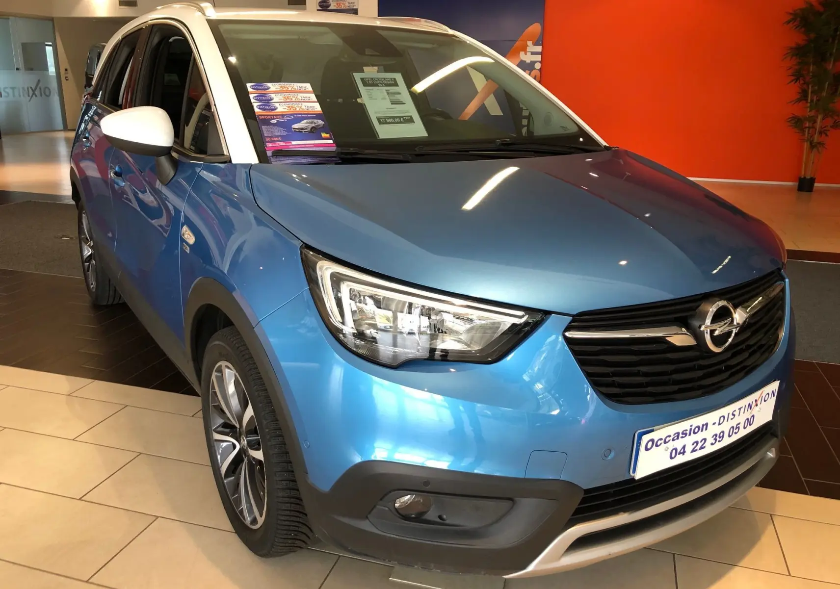 Opel Crossland X bleu métallisé en 3/4 avant droit, avec toit blanc et jantes alliage biton noir.