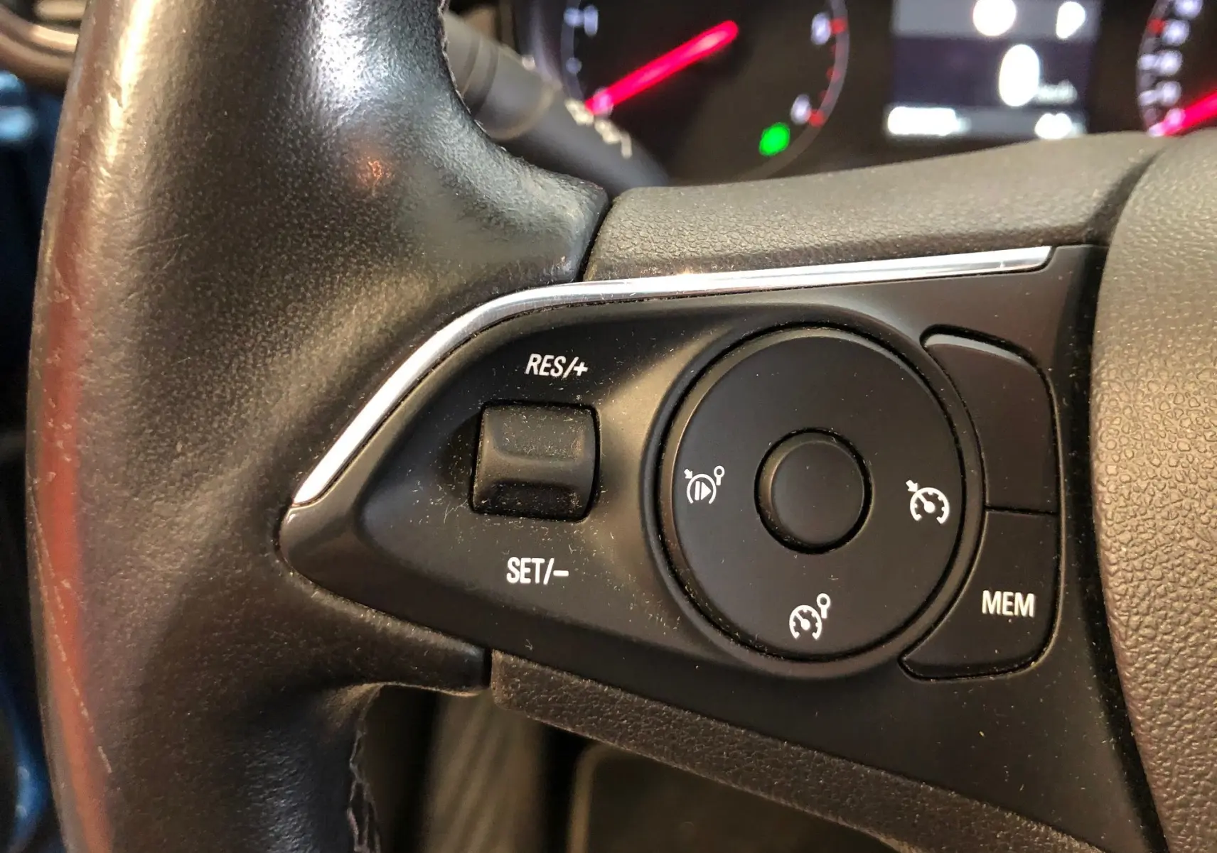 Gros plan sur les commandes de régulateur de vitesse au volant noir de l'Opel Crossland X 2019.