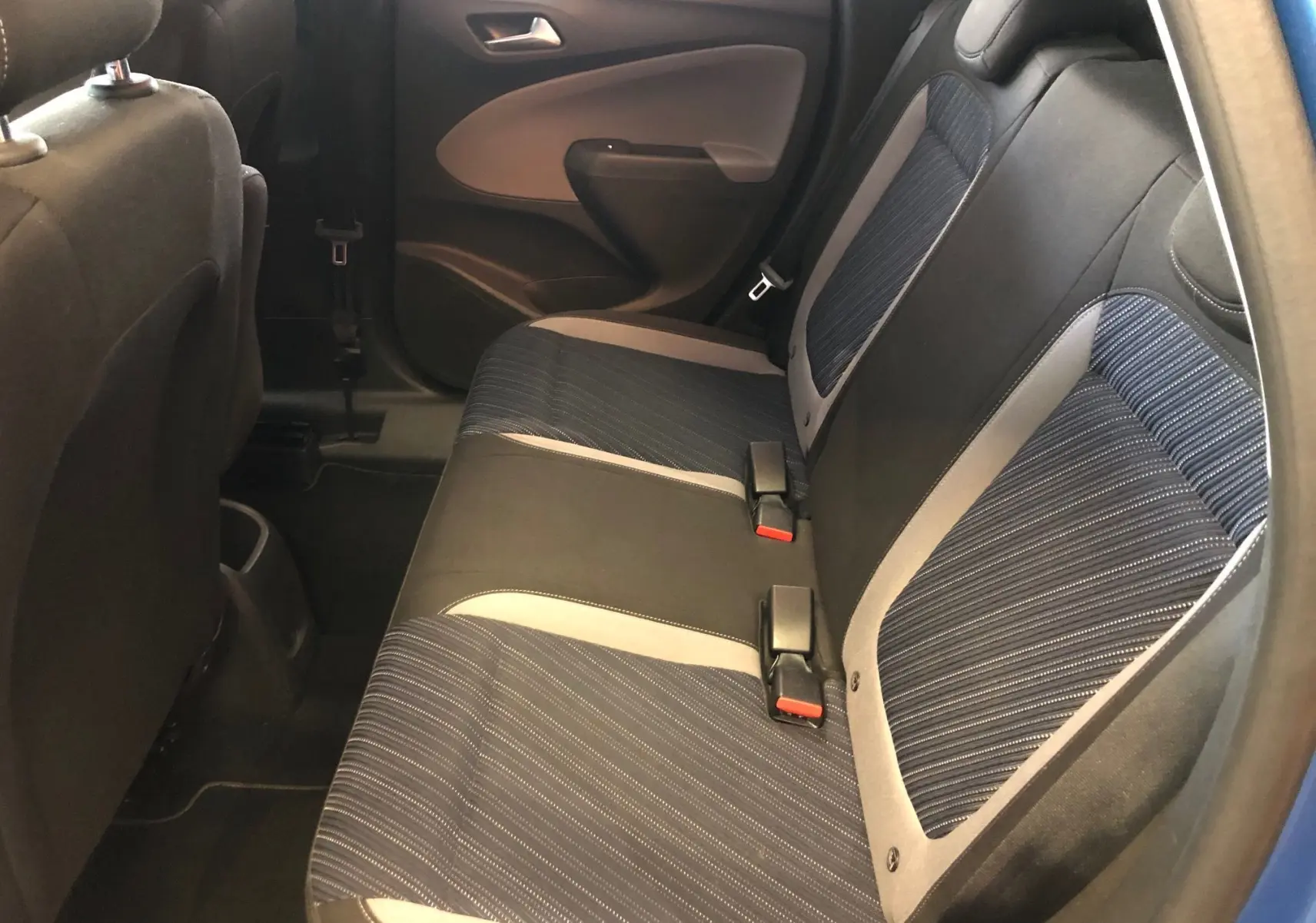 Vue intérieure côté arrière droit montrant les sièges arrière en tissu noir et bleu de l'Opel Crossland X 120 Ans.