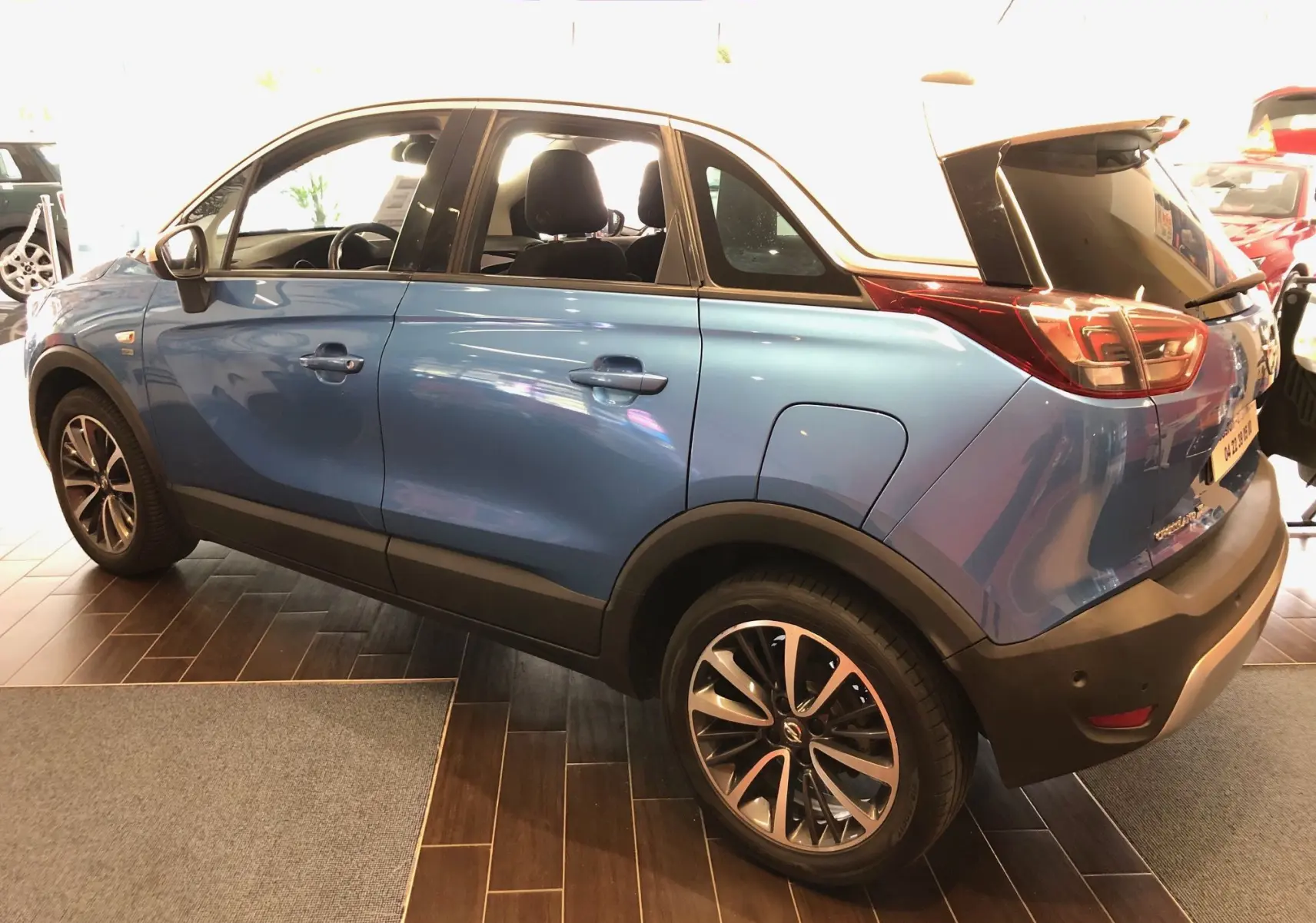 Opel Crossland X bleu métallisé en vue profil côté gauche, avec jantes alliage et toit blanc contrasté.
