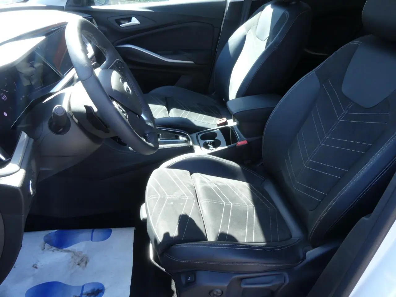 Vue intérieure côté conducteur de l’Opel Grandland 2024, sièges en Alcantara noir avec surpiqûres blanches.