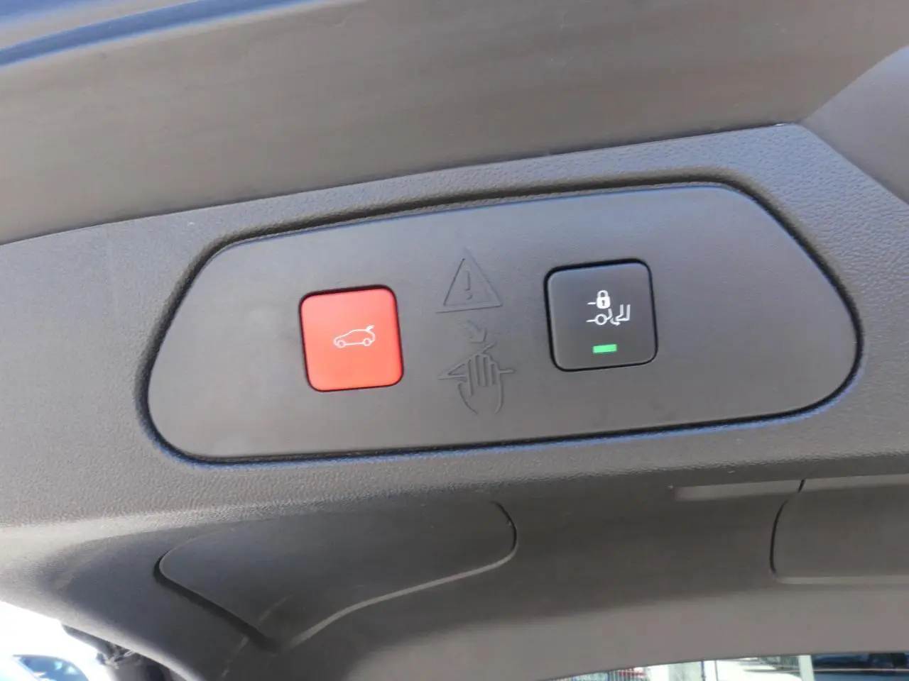 Gros plan sur les boutons d'ouverture mains-libres du hayon du coffre du Opel Grandland blanc métallisé 2024.