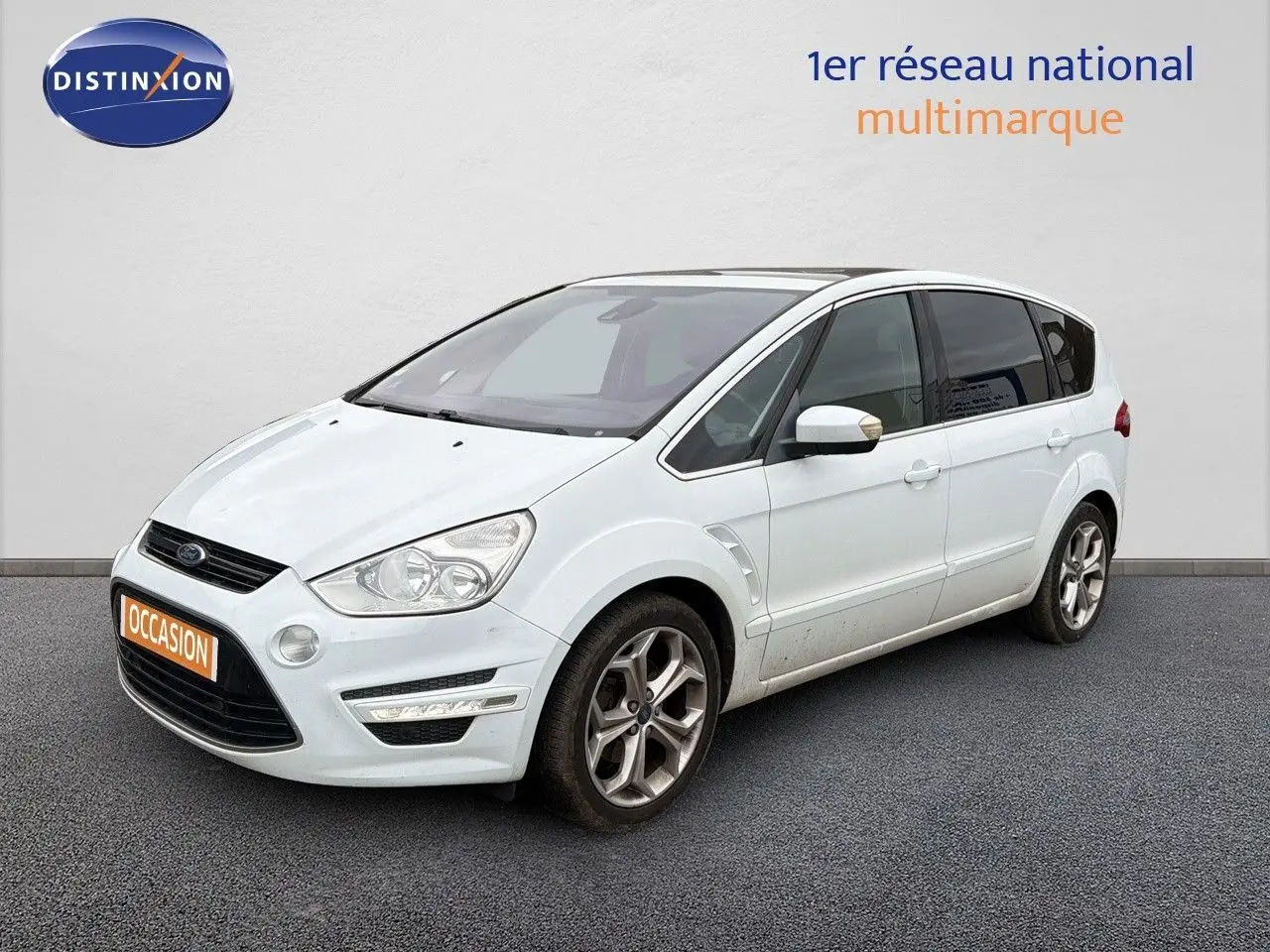 Ford S-MAX blanc vue 3/4 avant droit, avec jantes alliage et toit panoramique sombre visible.