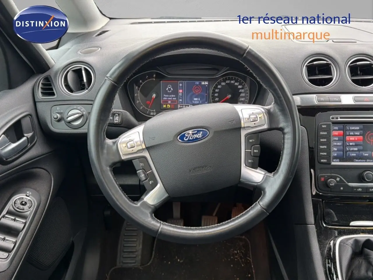 Vue intérieure centrée sur le volant noir du Ford S-MAX 2013 avec tableau de bord et console centrale visibles.