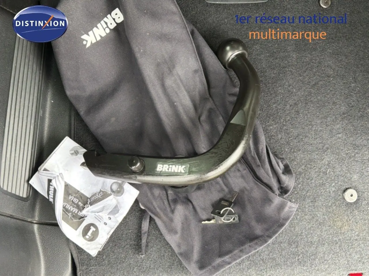 Gros plan sur une boule d’attelage Brink noire posée sur un tapis gris à l’intérieur d’un Ford S-MAX blanc de 2013.