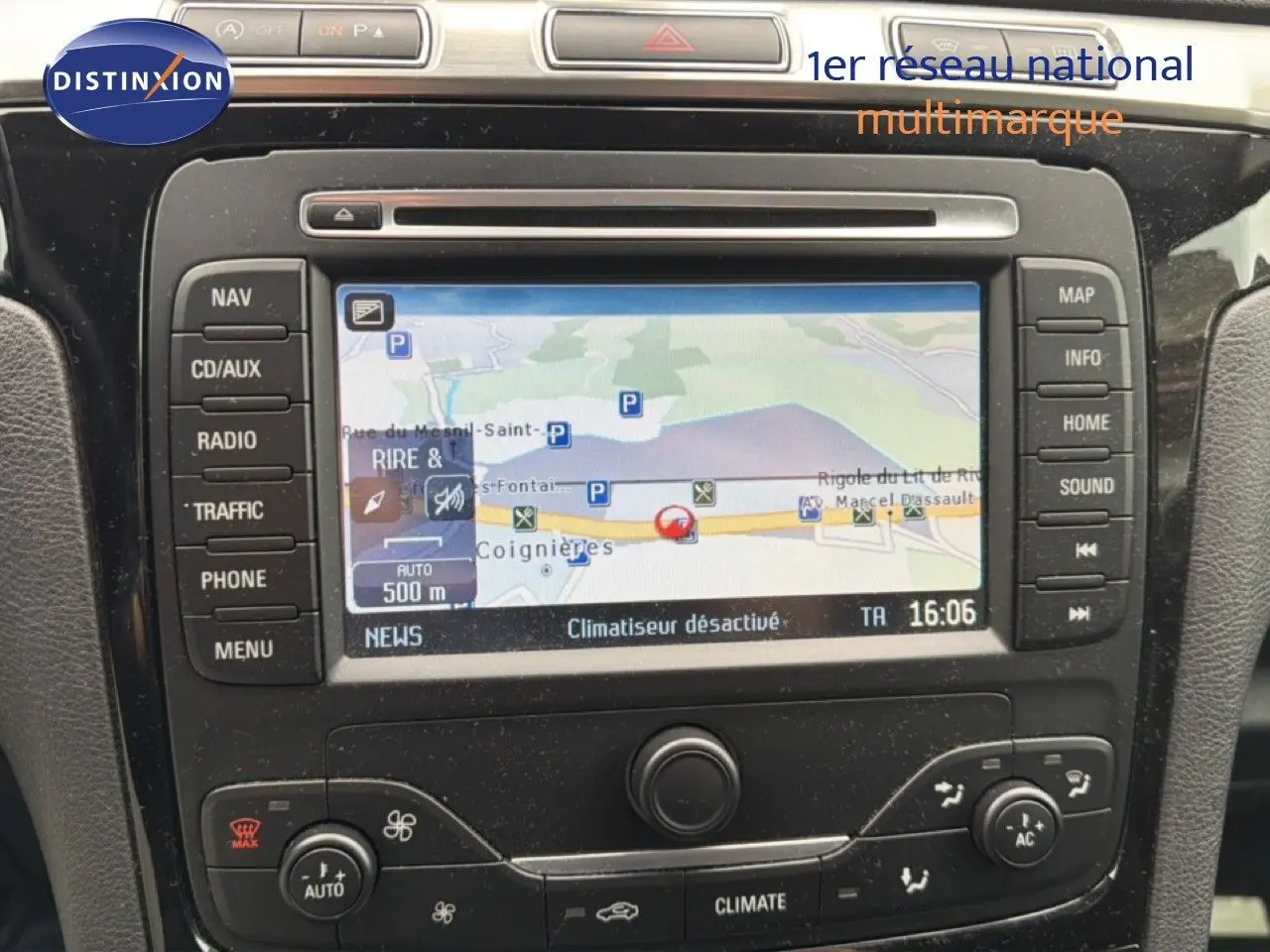Vue rapprochée du tableau de bord du Ford S-MAX blanc de 2013, mettant en valeur l’écran GPS et les commandes de climatisation.
