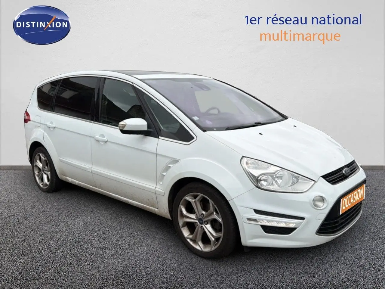 Ford S-MAX blanc en 3/4 avant droit, montrant ses jantes alliage et ses vitres teintées.